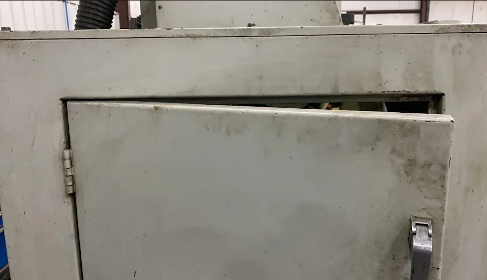 상단 간격이 고르지 않은 산업용 금속 도어, 래치 쪽 근처에서 처짐과 정렬 불량을 보입니다.