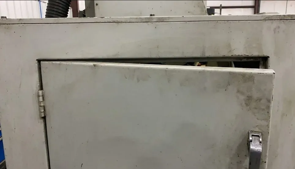 Porte de machine industrielle présentant un jeu irrégulier au niveau du cadre