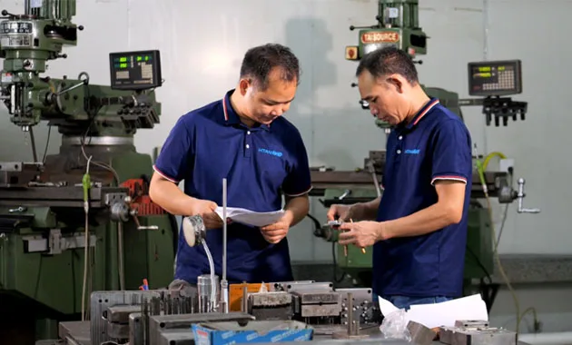 Dois engenheiros discutem as soluções de dobradiças de elevação da HTAN para armários e caixas industriais.